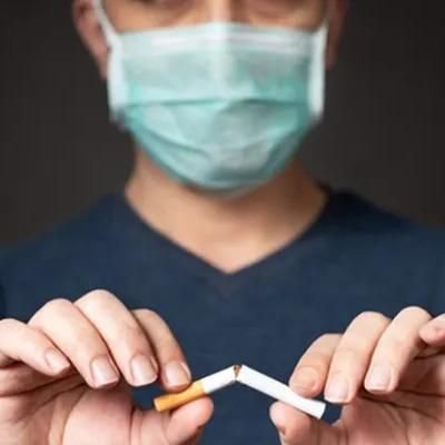 Fotografia de homem usando máscara quebrando um cigarro