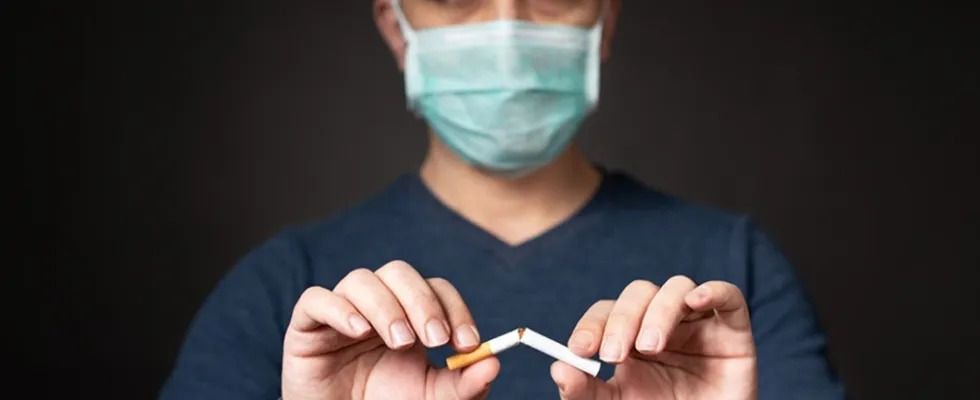 Fotografia de homem usando máscara quebrando um cigarro